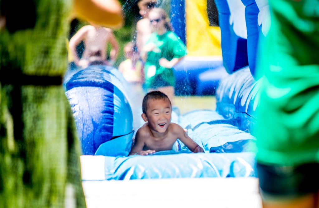kids playing on an inflatable slip and slide